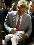  ?? BUTCH DILL — THE ASSOCIATED PRESS ?? Alabama head coach Nick Saban signs autographs during SEC Media Days Wednesday in Hoover, Ala.