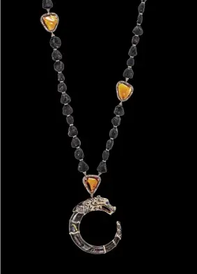  ??  ?? Cinta Legends Naga Trilogy Volcano necklace in 18K gold. Nega pendant in 18K rose gold and tiger iron detailed with pave-set brown diamonds is accented with a string of tiger iron, Madeira citrine, and black tourmaline beads.