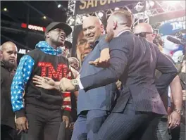  ?? Gary Coronado Los Angeles Times ?? FLOYD MAYWEATHER JR., left, and Conor McGregor exchange defiant looks as UFC President Dana White gets between them at Staples Center.