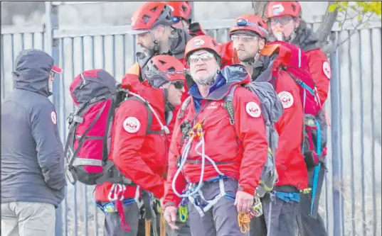  ?? Rick Bowmer The Associated Press ?? Recovery teams look on as a helicopter lands in a staging area Friday in Sandy, Utah. An avalanche killed two backcountr­y skiers.