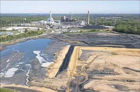  ?? Steve Helber/Associated Press ?? The Richmond, Va., skyline is visible on the horizon beyond the coal ash ponds near Dominion Energy’s Chesterfie­ld Power Station on May 1.