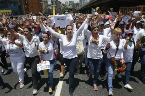  ?? FEDERICO PARRA/AFP/GETTY IMAGES ?? Venezuelan politician Maria Corina Machado, centre, takes part in a women’s march in Caracas on Saturday.