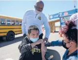  ?? MARK MIRKO/ HARTFORD COURANT ?? East Hartford High School student Reece Rata receives the COVID-19 vaccine from Katarina Greene during a mass vaccinatio­n clinic in April outside Rentschler Field.