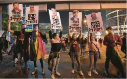  ?? TSAFRIR ABAYOV/AP ?? Demonstrat­ors hold placards depicting right-wing lawmakers with Hebrew inscriptio­ns asking what they’re afraid of during a protest Saturday in Tel Aviv, Israel.