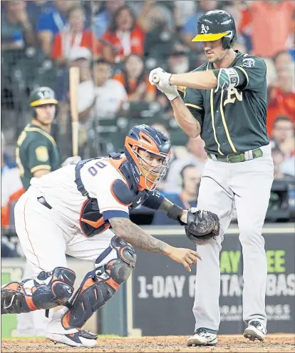  ?? PHOTOS BY MICHAEL WYKE — THE ASSOCIATED PRESS ?? Astros catcher Martin Maldonado tags out Stephen Piscotty after his swinging third strike to end the top of the ninth inning.