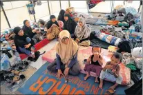  ?? AP PHOTO ?? An Indonesian family who escaped from the Islamic State group in Raqqa gather inside their tent at a refugee camp, in Ain Issa, Syria.