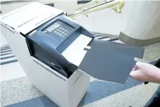  ?? JULIE JOCSAK/ STANDARD FILE PHOTO ?? A City of St. Catharines election co- ordinator is shown with a ballot in a secrecy sleeve to be fed into a vote- tabulating machine.