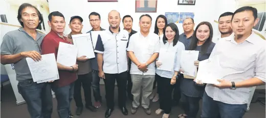  ??  ?? KENANGAN: Henry (tujuh kiri) bergambar bersama wakil-wakil kontraktor selepas Majlis Penganuger­ahan dan Serahan Inden Projek RMR1M Untuk Tasik Biru di pejabatnya, Pusat Khidmat ADUN Tasik Biru, Bau, semalam.