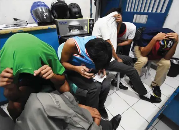  ?? PAUL JUN E. ROSAROSO ?? Six senior high school students cover their faces after they were caught having pot session in Barangay Sambag 1, Cebu City. Two of them are below 18 years old.