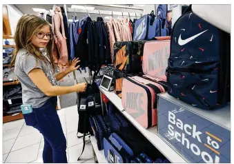  ??  ?? Sophie Henkels, 11, checks out new lunch boxes and backpacks at the Centervill­e Kohl’s store on Friday. Ohio’s back-to-school, tax-free weekend begins on Aug. 2 this year.