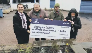 ??  ?? Esther, Bob, Christine and Kevin receive the cheque from Easington Colliery Co-op to buy tools and plants for Easington Colliery in Boom.