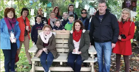  ??  ?? Relatives and friends of Hazel Somers at the bench placed in her memory under the tree beside the offices of Nurture at An Grianan .