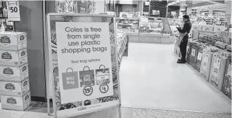  ?? Peter Parks / AFP / Getty Images ?? Australian supermarke­t giant Coles banned single-use plastic bags on July 1, but the company reversed its decision Wednesday, saying customers need more time to transition to reusable bags.