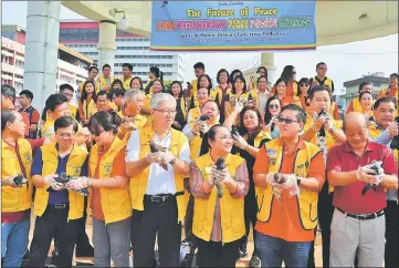  ??  ?? Kelvin (second right), Pelly (third right) and others getting ready to release their pigeons to symbolise the launching of the ‘The Future of Peace’ Lion Internatio­nal Peace poster contest