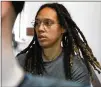  ?? ALEXANDER ZEMLIANICH­ENKO/AP ?? WNBA star Brittney Griner, a two-time Olympic gold medalist, is escorted to a courtroom for a hearing Monday in Khimki, outside Moscow. Griner’s trial begins Friday.