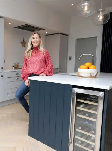  ??  ?? TOP LEFT: Interiors buyer Bronagh Page and her husband extended into their garden, which has made the garden smaller, but Bronagh says they now use it more
ABOVE: Bronagh in her extended kitchen. The pale-grey units are from Woodie’s. For contrast, she had the solid-wood island painted navy, and the quartz worktops are from Miller Brothers