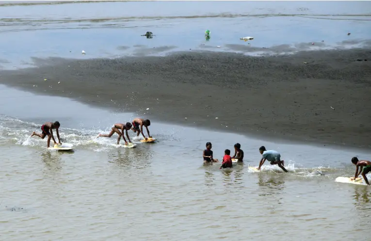  ?? BING GONZALES ?? CHILDREN have fun racing with improvised boats using styrofoam during low tide at the shoreline of Matina Aplaya.