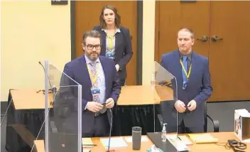  ?? AP ?? In an image taken from video, defense attorney Eric Nelson (left), defendant Derek Chauvin (right) and Nelson’s assistant Amy Voss (background) introduce themselves to jurors at Monday’s court proceeding.