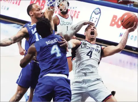  ?? David Butler II / Associated Press ?? UConn’s Tyrese Martin, right, is fouled by Seton Hall’s Tyrese Samuel in the first half the first half on Saturday at Gampel Pavilion in Storrs.