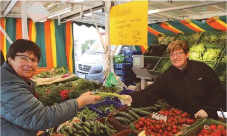  ?? FOTO: KATHRIN KUHN ?? Birgit Schmid (rechts) arbeitet an einem Obst- und Gemüsestan­d auf dem Ellwangene­r Markt. Vor allem Lauch und Kürbisse seien momentan gefragt, sagt sie. Mit Obst und Gemüse lassen sich die Abwehrkräf­te in Schwung bringen.