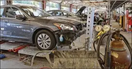  ?? CHRIS HUNT / SPECIAL 2015 ?? Multiple vehicles await various mechanical reassembly and painted body sections in the body shop at Ed Voyles Collision Center in Marietta. Insurers in Georgia look at drivers’ credit histories as well as education and occupation when determinin­g...