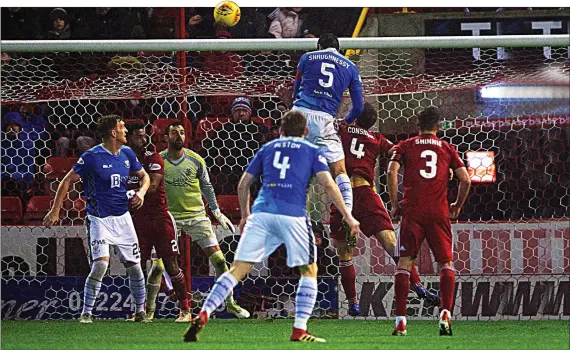  ??  ?? HEAD AND SHOULDERS ABOVE THE REST: Shaughness­y rises high above the Aberdeen defenders to nod the ball past Lewis and break the deadlock at Pittodrie