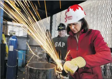  ?? Dan Riedlhuber, Reuters ?? Wildrose Leader Danielle Smith grinds a pipe stand at Tempco Drilling in Nisku. Smith has expressed doubts about the science behind the theory of climate change, drawing criticism from both her rivals and environmen­talists.