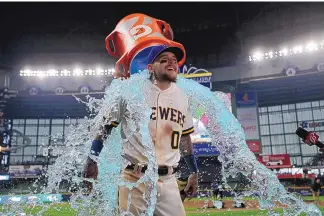  ?? AARON GASH/ASSOCIATED PRESS ?? Milwaukee’s Brice Turang is doused with Gatorade by teammate Willy Adames after the Brewers beat the Mets, 10-0 in Milwaukee. Turang hit his first career home run on Monday— a grand slam.