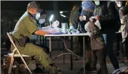  ?? JULIO CORTEZ - THE ASSOCIATED PRESS ?? A child rests its head on a table as a U.S. Customs and Border Protection officer processes migrants after they crossed into the U.S., early Wednesday, March 24, 2021, in Roma, Texas.