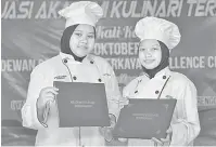  ?? — Gambar Bernama ?? CEMERLANG: Pelajar Akademi Kulinari Terengganu Wan Fadhlin Nasuha (kiri) dan Sharifah Nur Liyana dipilih sebagai pelajar cemerlang bagi pengambila­n kelapan dan kesembilan pada Majlis Graduasi Akademi Kulinari Kelima di Perkaya Excellence Center.