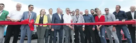  ??  ?? David Foster, centre, prepares to cut the ceremonial ribbon, surrounded by celebritie­s, track collaborat­ors and invited guests.