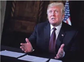  ?? MANDEL NGAN, AFP/GETTY IMAGES ?? President Donald Trump speaks to journalist­s Thursday after talking to members of the military via teleconfer­ence from his Mar-a-Lago resort in Palm Beach, Fla.