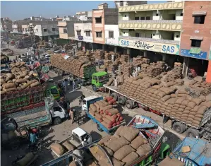  ?? AP ?? FOOD SUPPLY: Labourers unload onions and potatoes from trucks at a wholesale fruit and vegetable market in Karachi on Saturday. The government has decided to allow movement of goods transport to avoid shortage of foodstuff in the country. —