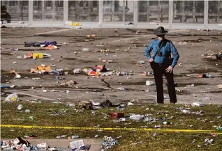  ?? Charlie Riedel/Associated Press ?? A law enforcemen­t officer stands amid debris after a shooting during the Kansas City Chiefs’ Super Bowl celebratio­n Wednesday in Kansas City, Mo.