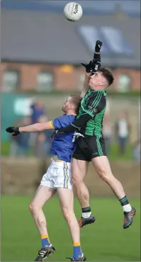 ??  ?? Derek Maguire soars over Fergal Scully.