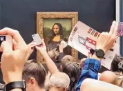  ?? @KLEVISL007/ASSOCIATED PRESS ?? A security guard cleans the smeared cream from the glass protecting the Mona Lisa at the Louvre Museum.