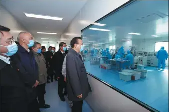  ?? PROVIDED BY WWW.GOV.CN ?? Premier Li Keqiang inspects mask production at a medical equipment manufactur­er in Beijing on Friday. The premier ordered the company to increase production to ensure supplies amid the country’s fight against the novel coronaviru­s outbreak.