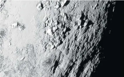  ?? NASA/APL/SwRI via Getty Images ?? In this handout provided by the National Aeronautic­s and Space Administra­tion, a close-up image taken by the New Horizons spacecraft
as it passed by the dwarf planet shows a region near Pluto’s equator featuring a range of mountains rising as high as...