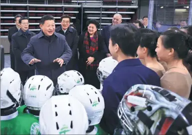  ?? LAN HONGGUANG / XINHUA ?? President Xi Jinping talks with elementary school ice hockey players and other athletes at the Wukesong Arena in Beijing on Friday.
