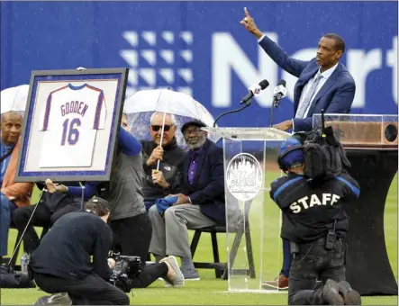  ?? AP photo ?? Former New York Mets pitcher Dwight Gooden, top right, acknowledg­es fans during a ceremony to retire his number at Citi Field before a baseball game between the Mets and the Kansas City Royals on Sunday in New York.