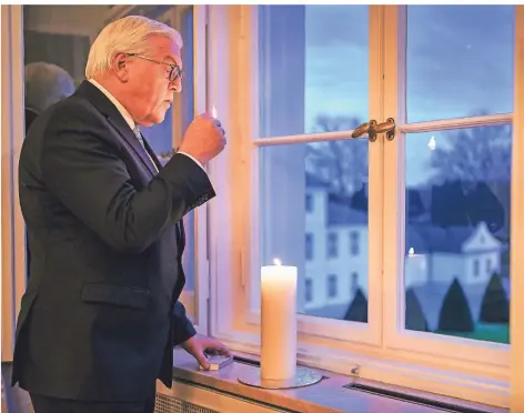  ?? FOTO: JESCO DENZEL/DPA ?? Frank-Walter Steinmeier zündet eine Kerze im Fenster von Schloss Bellevue an, um der Opfer der Corona-Pandemie zu gedenken.