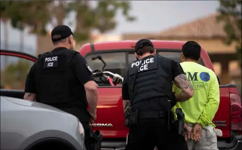  ?? AP PHOTO/GREGORY BULL ?? In this July 8 photo, a U.S. Immigratio­n and Customs Enforcemen­t (ICE) officers detain a man during an operation in Escondido, Calif.