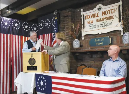  ?? PAUL HAYES/CALEDONIAN-RECORD VIA AP FILE (2020) ?? Selectman Les Otten, left, casts the first ballot of the New Hampshire presidenti­al primary election during the midnight vote Feb. 11, 2020, at The Balsams Resort in Dixville Notch, N.H. The hamlet is home to the first votes in the traditiona­l frist-in-the-nation primary. But the future of New Hampshire’s status as first is on shaky ground, as the national Democratic Party seeks to reassert its control over a process that’s been centered on traditions and dominated by smaller, predominan­tly white states.