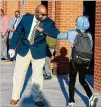  ??  ?? Jackson Elementary Principal William Greene elbow-bumps students returning for inperson learning Monday.