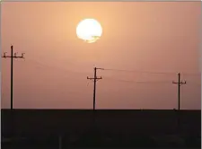  ?? BING GUAN/BLOOMBERG ?? The sun rises over power lines near Imperial, Calif., in 2020.