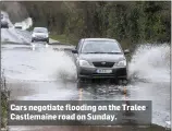  ?? Cars negotiate flooding on the Tralee Castlemain­e road on Sunday. ??