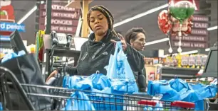  ?? Pittsburgh Post-Gazette ?? In a 2019 photo, Giant Eagle Market District employee Deera Robinson loads groceries in plastic bags at the Waterworks Shopping Center.