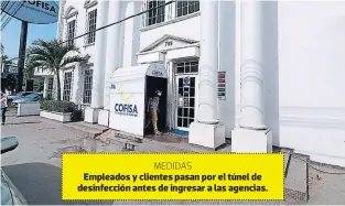  ??  ?? MEDIDAS
Empleados y clientes pasan por el túnel de desinfecci­ón antes de ingresar a las agencias.