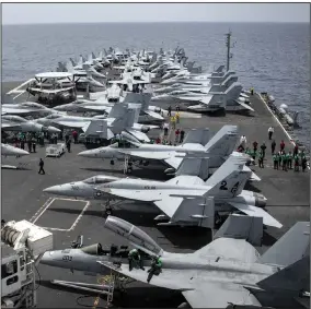  ?? AP/COMMUINCAT­IONS SPECIALIST 3RD CLASS GARRETT LABARGE ?? Sailors search for foreign objects and debris on the flight deck of the Nimitz-class aircraft carrier USS Abraham Lincoln in the Arabian Sea on Sunday.