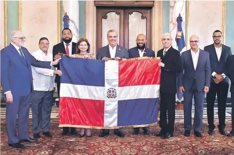  ?? ?? El presidente Luis Abinader, acompañado de Francisco Camacho, Raquel Peña y Vitelio Mejía, entrega la bandera al Licey que participar­á en la Serie del Caribe. Recibe César Valdez, Emilio Bonifacio, Ricardo Ravelo y Gilbert Gómez.